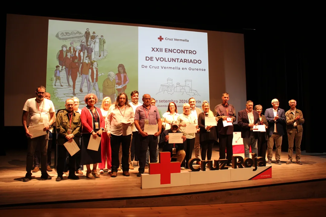 Persoas recoñecidas cos Diplomas e as Medallas de Bronce posan no escenario do Auditorio Municipal de Verín xunto aos representantes de Cruz Vermella.