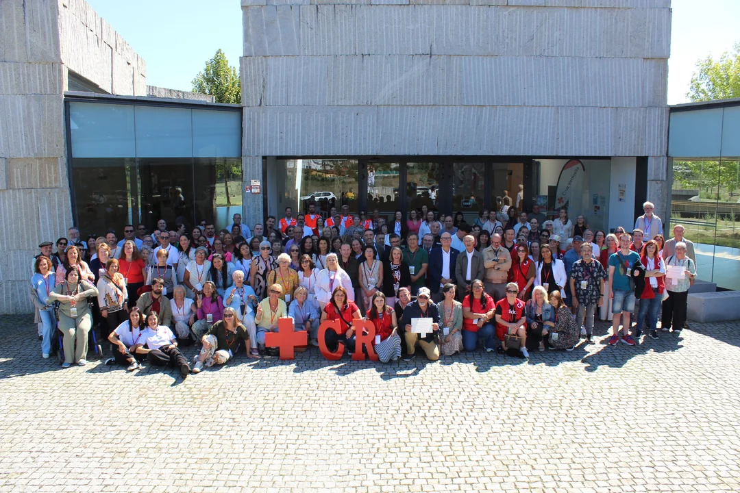 Foto de familia das persoas voluntarias participantes no XXII Encontro Provincial de Voluntariado de Cruz Vermella, diante do Auditorio Municipal de Verín.